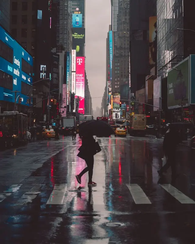 person with umbrella walking in NYC on a cloudy day during NYC pedestrian crosswalk accidents awareness