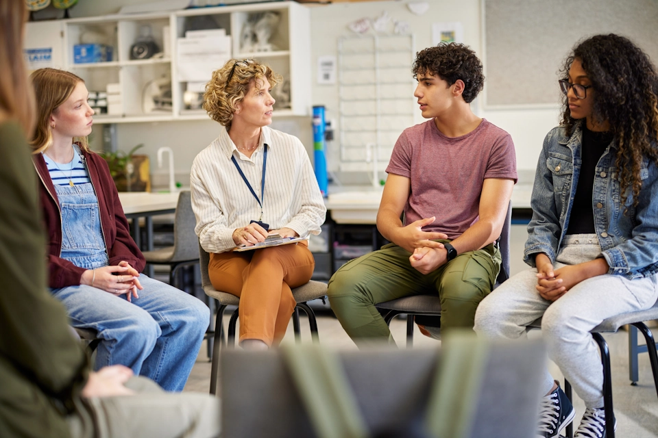 Teenagers work together with a therapist in a group therapy class