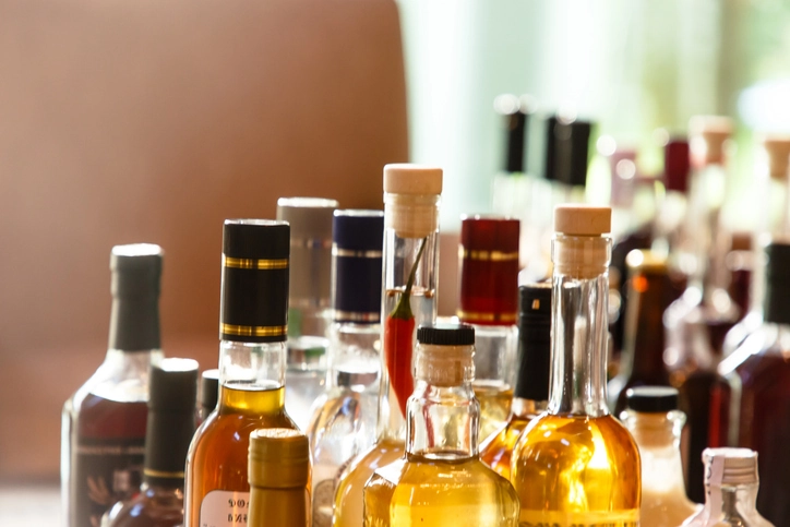 Bottles of alcohol line a shelf.