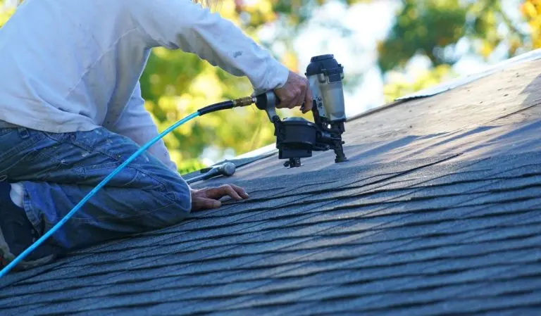 roofer repairing asphalt roof with nail gun, Roseville, MN